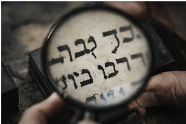 Magiah using magnifying glass to inspect ksav